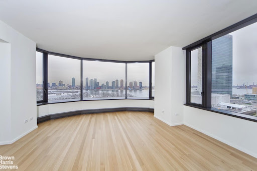 Panoramic city and river view from empty room in this luxury property for sale in New York ($3,250,000)