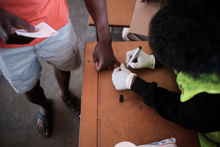 A ZEC election officer marks a voter's finger during the Zimbabwean harmonised elections at Emakhandeni Secondary School in Bulawayo, Zimbabwe.