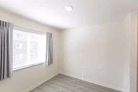 Bedroom with wood-inspired flooring and white walls