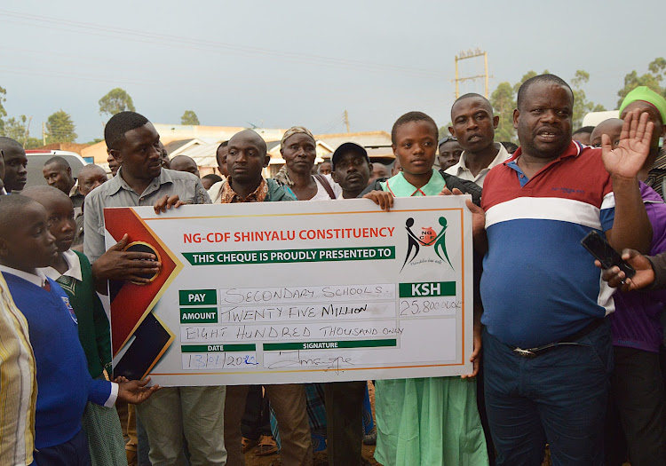 Shinyalu MP Justus Kizito presents a dummy cheque for needy students in secondary schools