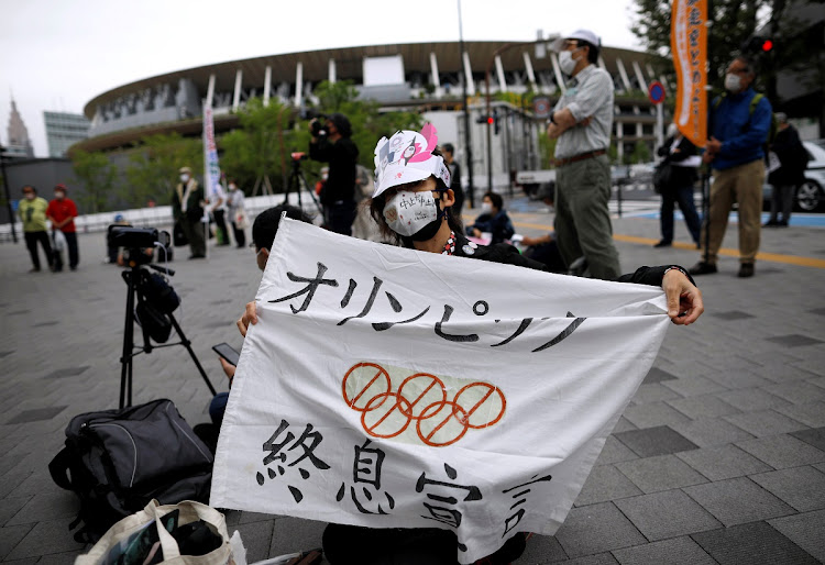 A woman protests against the Olympic Games outside the National Stadium and Japanese Olympic Committee headquarters in Tokyo.