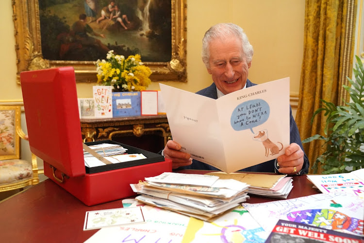 Britain's King Charles reads cards and messages sent by well-wishers after his cancer diagnosis, in the 18th Century Room of the Belgian Suite in Buckingham Palace.