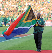 Mamelodi Sundowns' Caf Champions League winning coach Pitso Mosimane parades the SA flag before the Rugby Championship match between New Zealand and the Springboks at Loftus Stadium in Pretoria on Saturday October 6, 2018.