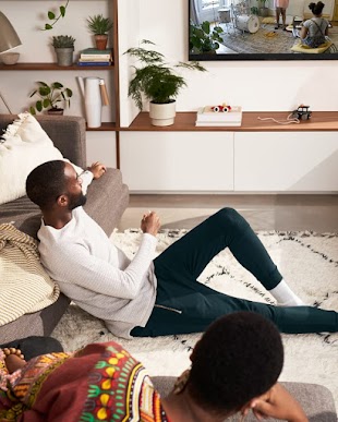 Two people looking at their Nest Cam feed on the TV.