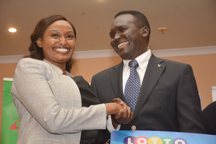 Soya founder Paul Tergat shares a light moment with Lotto Foundation CEO Dr. Joan Mwaura after receiving a cheque of Sh1.2million