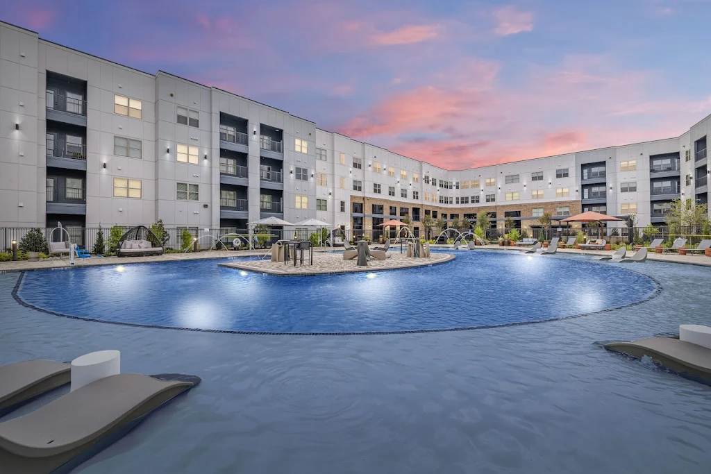 Swimming pool with apartment buildings in the background at dusk