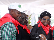 Zimbabwe's President Robert Mugabe, his son Chatunga (L) and wife, First Lady Grace Mugabe (R), cut the cake during celebrations marking his 90th birthday in Marondera, on February 23, 2014.