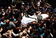 Mourners carry the body of senior Islamic Jihad commander Eyad Al-Hasani, who was killed in an Israeli strike, as they attend his funeral in Gaza City May 13, 2023.