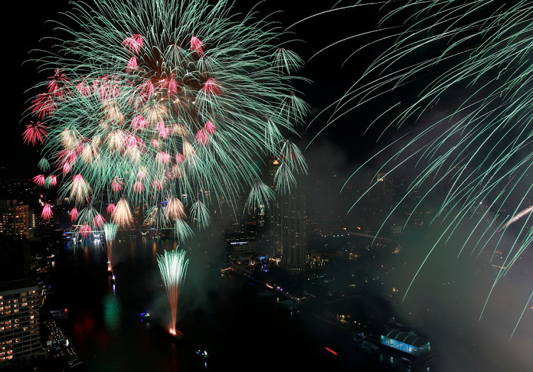 Fireworks explode over the Chao Phraya River during the 2022 New Year celebrations in Bangkok, Thailand.