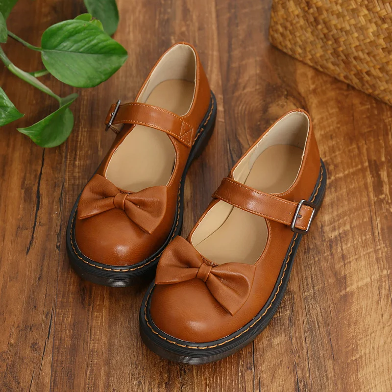 Ballerines Mary Jane rondes, style britannique, avec nœud mignon pour femmes. Chaussures plates marron pour un look féminin et charmant.