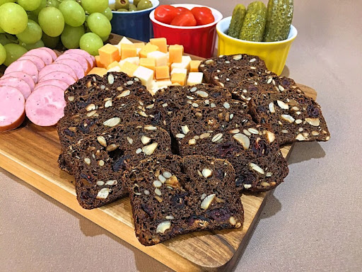 A charcuterie board with homemade Raincoast Crisps, sausage, cheese, pickles, etc.