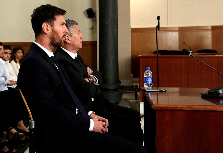 Barcelona's Argentine soccer player Lionel Messi (left) sits in court with his father, Jorge Horacio Messi, during their trial for tax fraud in Barcelona, Spain. Picture: REUTERS/ALBERTO ESTEVEZ