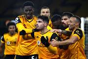 Pedro Neto of Wolves celebrates with teammates Nelson Semedo and Ruben Neves and Marcal and Owen Otasowie after scoring their side's winning goal during the Premier League match against Chelsea at Molineux on December 15, 2020 in Wolverhampton
