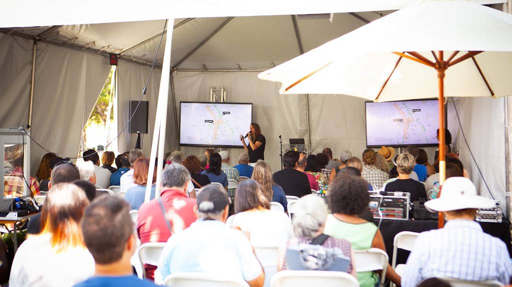 People gathered around a speaker giving a presentation.