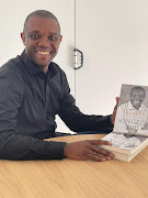 Songezo Zibi with copies of his book