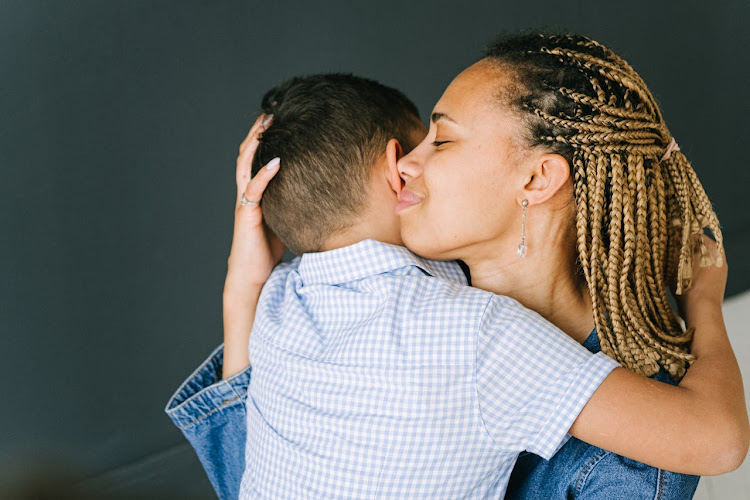 A mother hugs her son