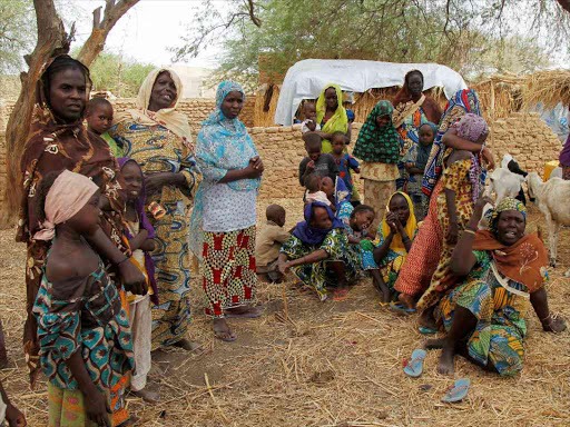 Nigerian refugees, who fled from their village into Niger following Boko Haram attacks, stand in the yard of their Nigerien host in Diffa in southeastern Niger June 21, 2016. /REUTERS