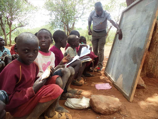 Class three Pupils at Nachuru primary school in Tiaty sub-county in Baringo County seated on stones while taking their lessons under a tree on Wednesday last week. The school is set to register for KCPE this year. PHOTO/JOSEPH KANGOGO