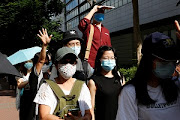 Supporters of Tong Ying-kit, the first person charged under the new national security law, greet a prison van outside West Kowloon Magistrates' Courts in Hong Kong, China July 6, 2020.  File Photo 