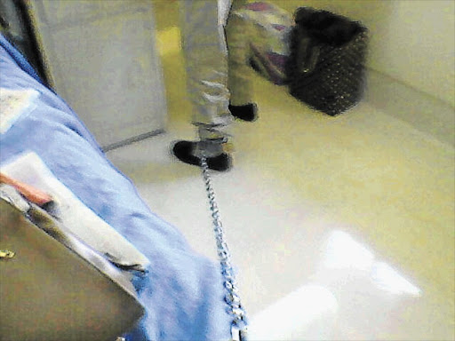 CHAINED: Clive Derby-Lewis is manacled to his bed in prison