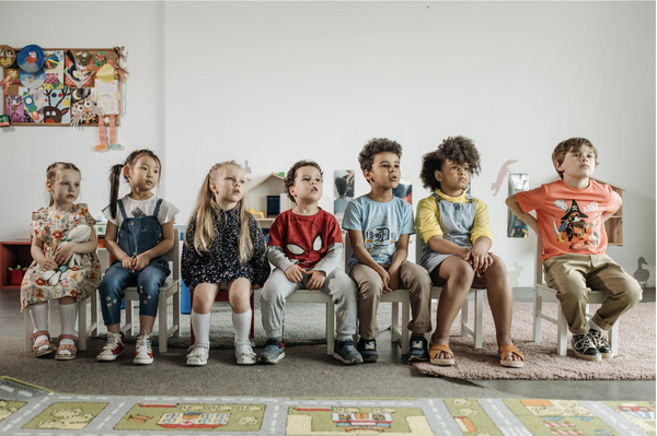 Children sitting on stools in preschool.