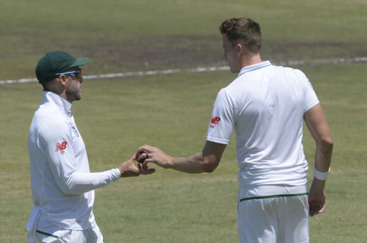 South Africa captain Faf du Plessis (L) hands the ball over to Morne Morkel (R) during day 1 of the 1st Sunfoil Test match between the Proteas and Australia at Sahara Stadium Kingsmead on March 01, 2018 in Durban, South Africa.