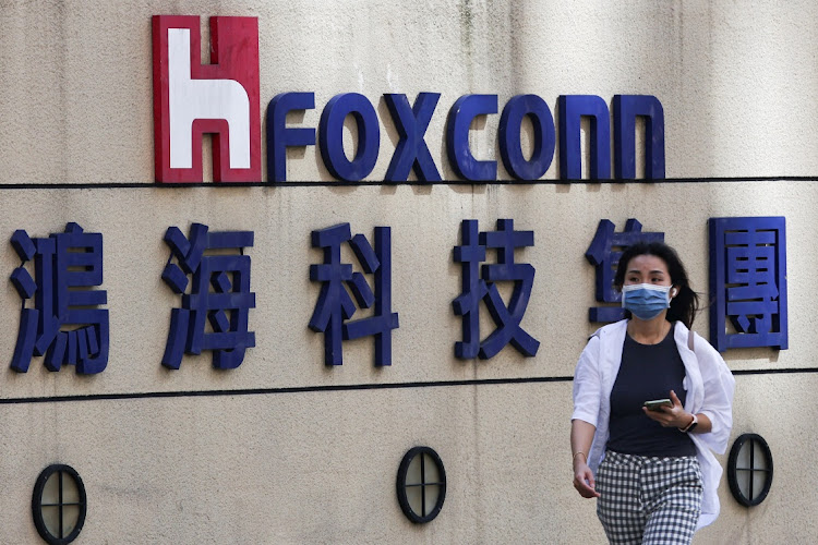 A woman walks past the logo of Foxconn outside the company’s building in Taipei, Taiwan. Picture: ANN WANG/REUTERS
