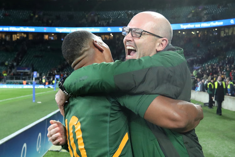 Springbok player Damian Willemse celebrates his side's victory with coach Jacques Nienaber after the match against England at Twickenham Stadium on November 26, 2022 in London.