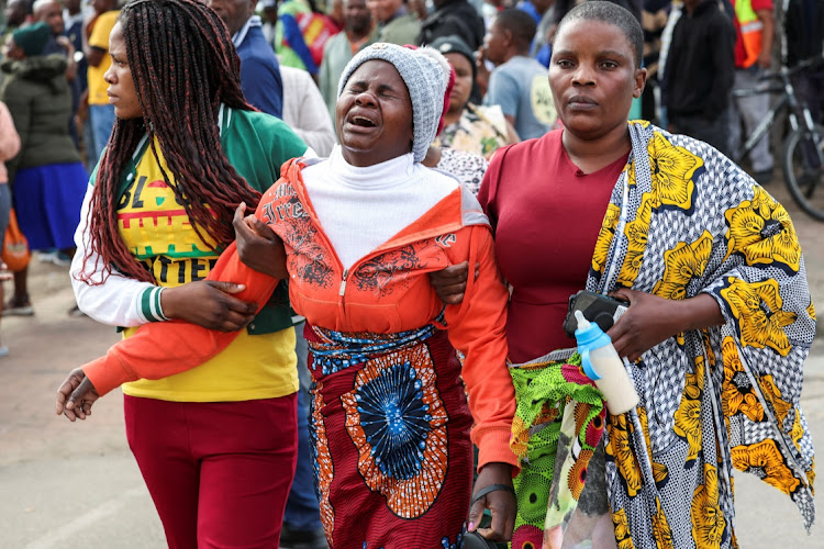 Families have gathered near the site where construction workers have been trapped under a building that collapsed in George on Monday.