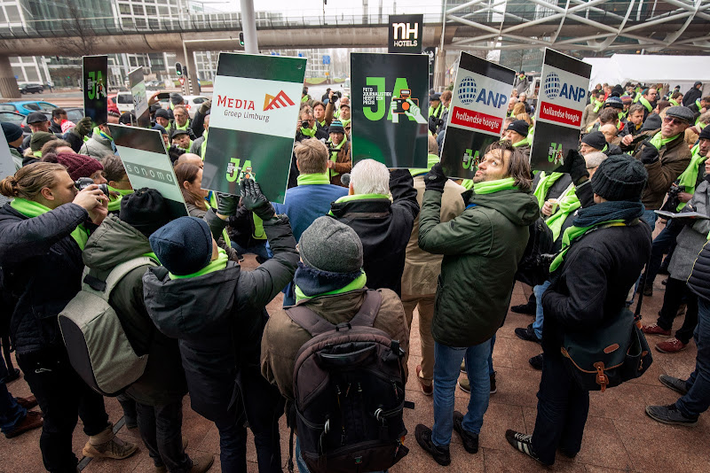 stakers met borden met namen van slecht betalende organisaties