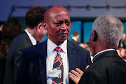 Patrice Motsepe, billionaire and chairman of African Rainbow Mineral, speaks with an attendee ahead of the special address by US President Donald Trump, on the opening day of the World Economic Forum (WEF) in Davos, Switzerland, on January 21 2020. 