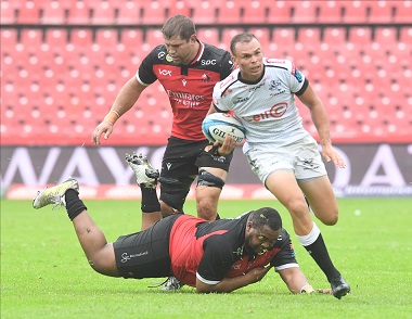 Curwin Bosch of the Sharks breaks away from a Lions player during their United Rugby Championship match against the Lions at Emirates Airline Park on February 18, 2023 in Johannesburg, South Africa.