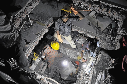 Rescue workers cut through the floors of the collapsed Rana Plaza building in Bangladesh yesterday in the hope of finding trapped survivors under the rubble