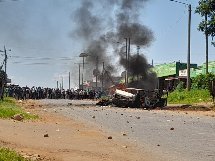 The police car burns following the raid by residents to the Nambale Police Station.