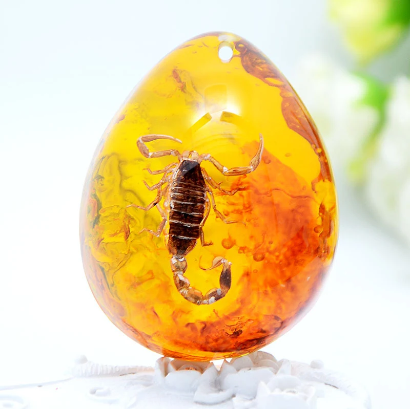 Pendentif en ambre avec insecte et cire d'abeille en forme de goutte. Ornez-vous d'un spécimen naturel unique, élégant et raffiné, idéal pour un cadeau.