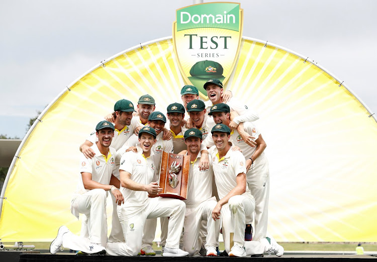 The Australian team celebrate with the Warne-Muralitharan Trophy after clinching a 2-0 Test series win over Sri Lanka at the Manoka Oval in Canberra.