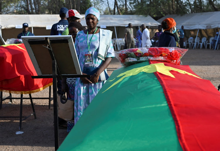 A relative of the former leader and revolutionary, Thomas Sankara, stands near the flag-draped coffins of Sankara and his companions before the burial ceremony in Ouagadougou, Burkina Faso, February 23 2023. Picture: ANNE MIMAULT/REUTERS