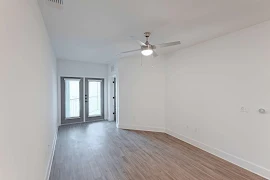 Living room with wood finish flooring, modern ceiling fan, and white walls