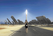 A woman walks at the new solar power plant Gemasolar in Fuentes de Andalucia, southern Spain.