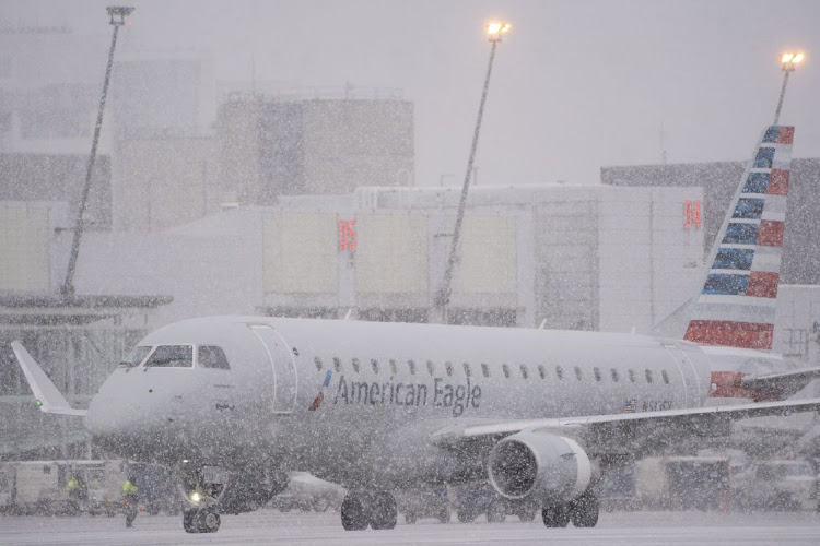 An American Eagle plane taxis during a snowstorm at Seattle-Tacoma International Airport in Seattle, Washington state, on December 20 2022. An estimated 112.7-million people will travel 85km or more from December 23 to January 2, up by 3.6-million from 2022, according to AAA, a provider of travel insurance. Picture: BLOOMBERG/DAVID RYDER