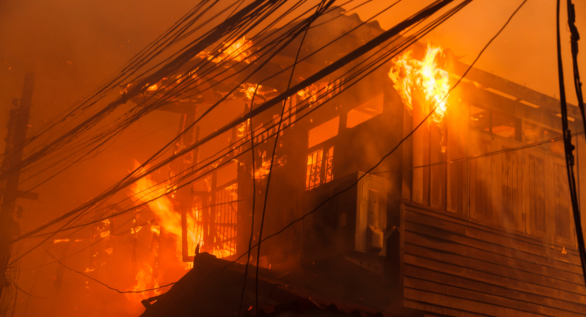 Intense house fire with billowing smoke and vibrant flames.