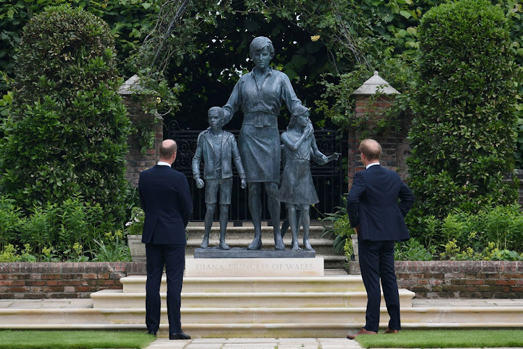 Princes William and Harry look at the statue they commissioned of their mother Diana, Princess of Wales, in the Sunken Garden at Kensington Palace.