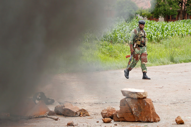 A soldier walks past a burning barricade in Harare, Zimbabwe, January 15 2019.