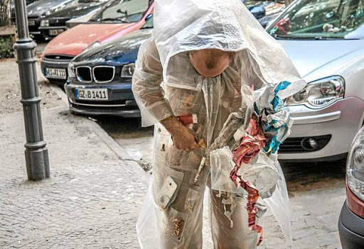 A still from the video performance of Kai Lossgott in his 'Hunter-gatherer' suit, collecting urban detritus for future categorisation.