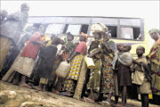 TERRIFIED: Displaced Congolese board a bus at the Ishasha refugee transit camp to a new camp. 30/11/2008. Pic. Peter Andrews.  © Reuters.