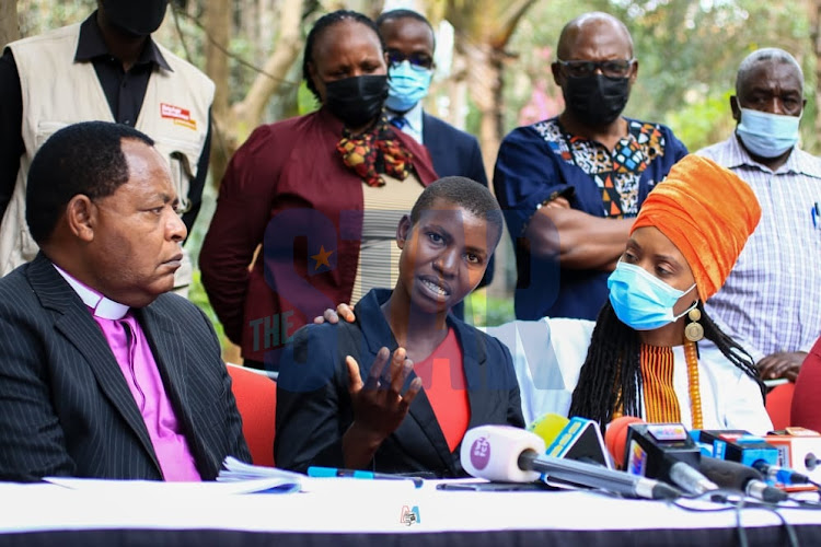 Janet Moraa(C) daughter of the late Jemimah Nyang'ate among the victims lynched on allegations of witchcraft speaks, flanked by Interfaith Religious Council of Kenya Executive Board member Bishop John Warari(L) and Kerubo Abuya(R) at Mayfair Hotel Nairobi on Thursday October 21, 2021.