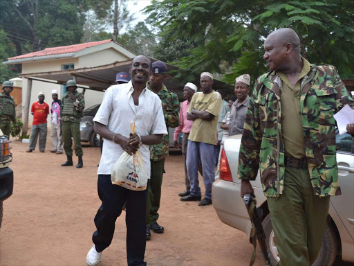 Mombasa republican council group chairman Omar Mwamnuadzi being escorted by heavily armed police officer to Kwale law court on Monday 1 February 2016 where he is facing three counts of being a member of an organized criminal group, contributing and receiving money against the law and incitement to violence which he has denied. He was told to pay Sh200, 000 bond and surety of the same amount to secure his release by a Kwale court. Photo by ALLOYS MUSYOKA