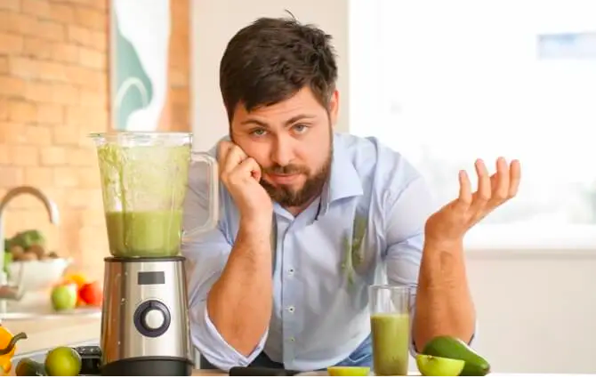 A man with old blender in kitchen