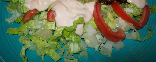 Side salad with dressing on a plate.