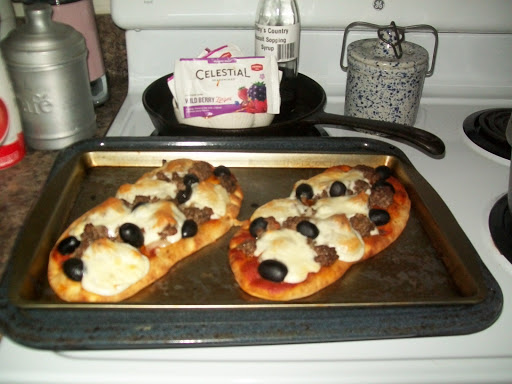 Cheese Burger Olive Pizza On Garlic Flat Bread on a cookie sheet.